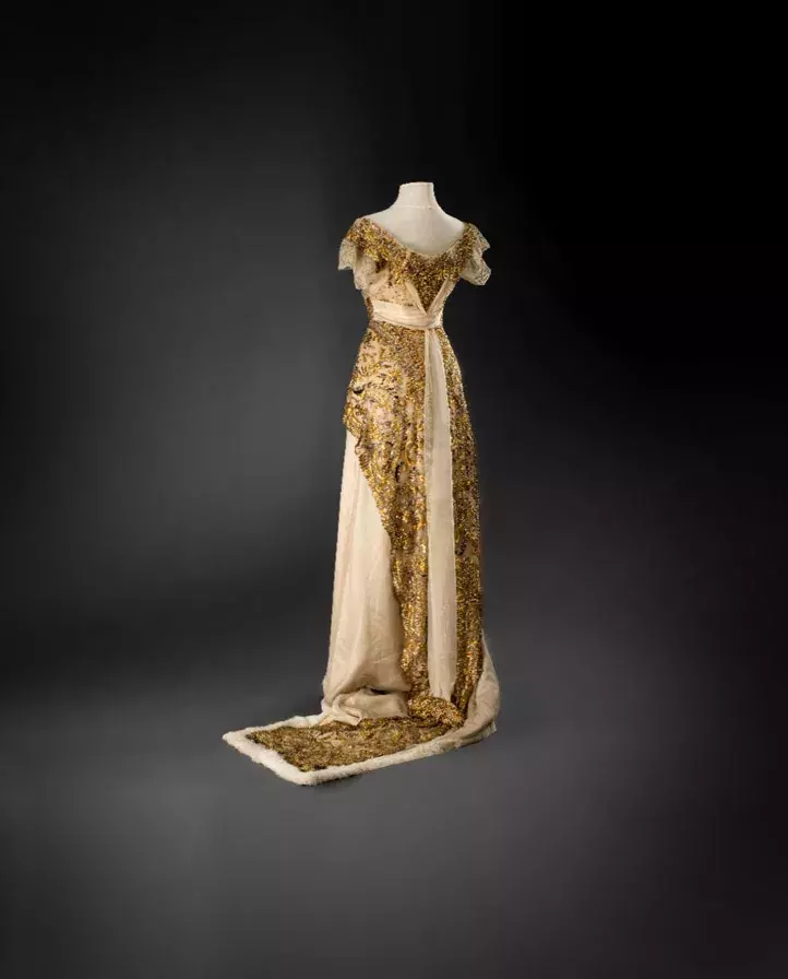 Plesová toaleta s tunikou, 1912–1913, vídeňský salon L.&H. Laufer, hedvábný satén a šifon, strojová krajka, výšivka lamelami a korálky, kožešinový lem (ze sbírek Uměleckoprůmyslového musea v Praze)