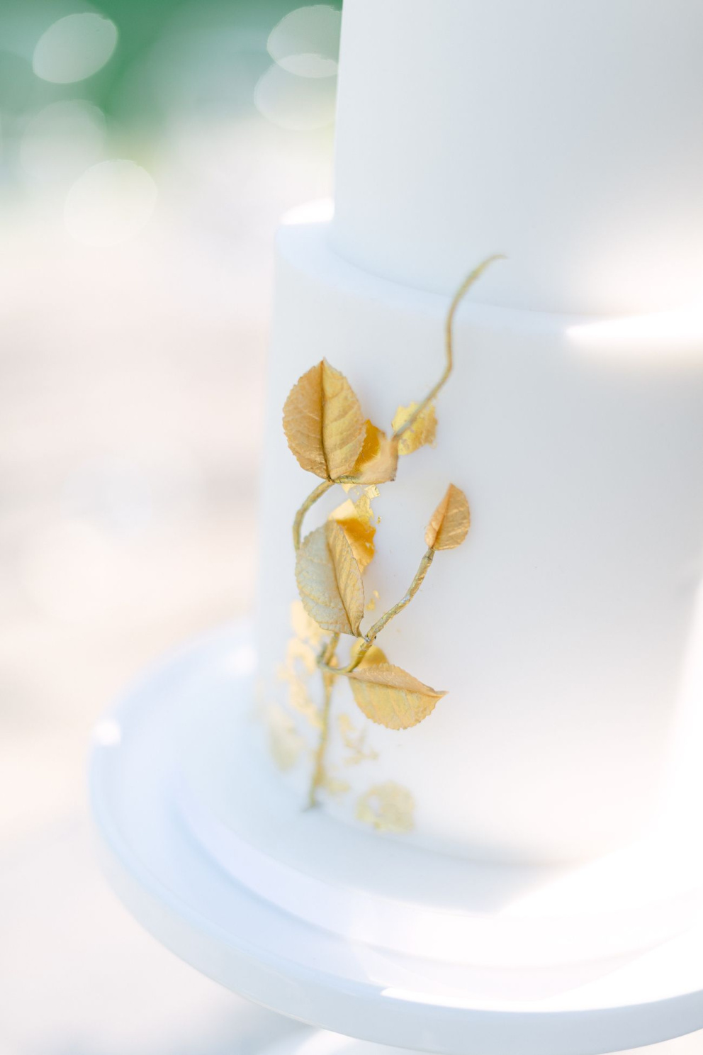 Minimalisticky provedené dorty jsou velmi trendy. Hladká bílá struktura kontrastuje s elegantním zlatým zdobením. Foto: Matěj Třasák. Výzdoba: Ivan Šablatúra.
