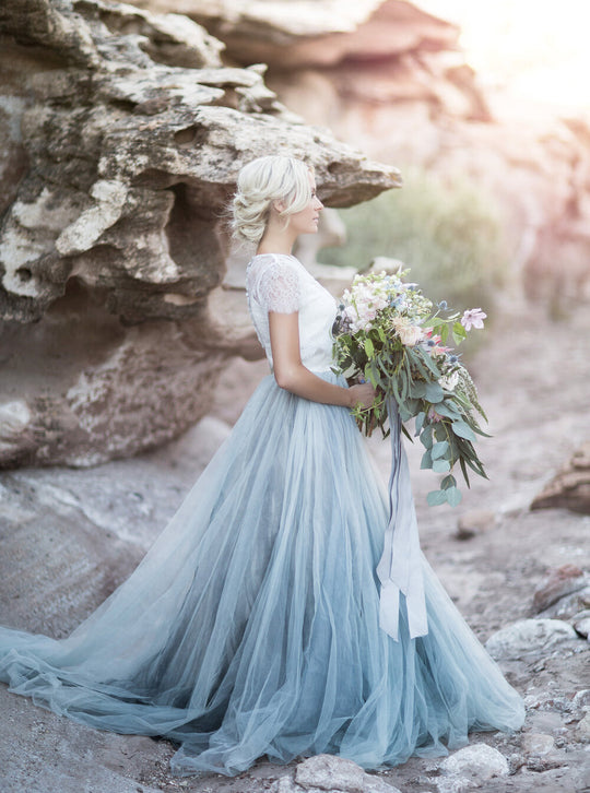 Sněhově bílý vršek v kombinaci s šifónovou bledě modrou sukní krásně ladí ke svatební kytici.
