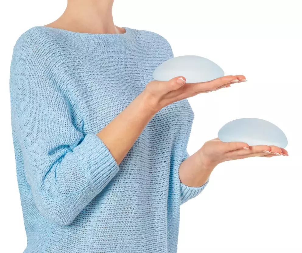 žena držící prsní implantáty