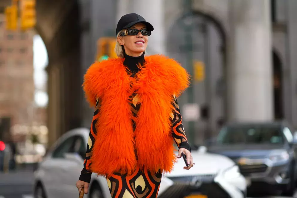 žena v oranžové chlupaté vestě