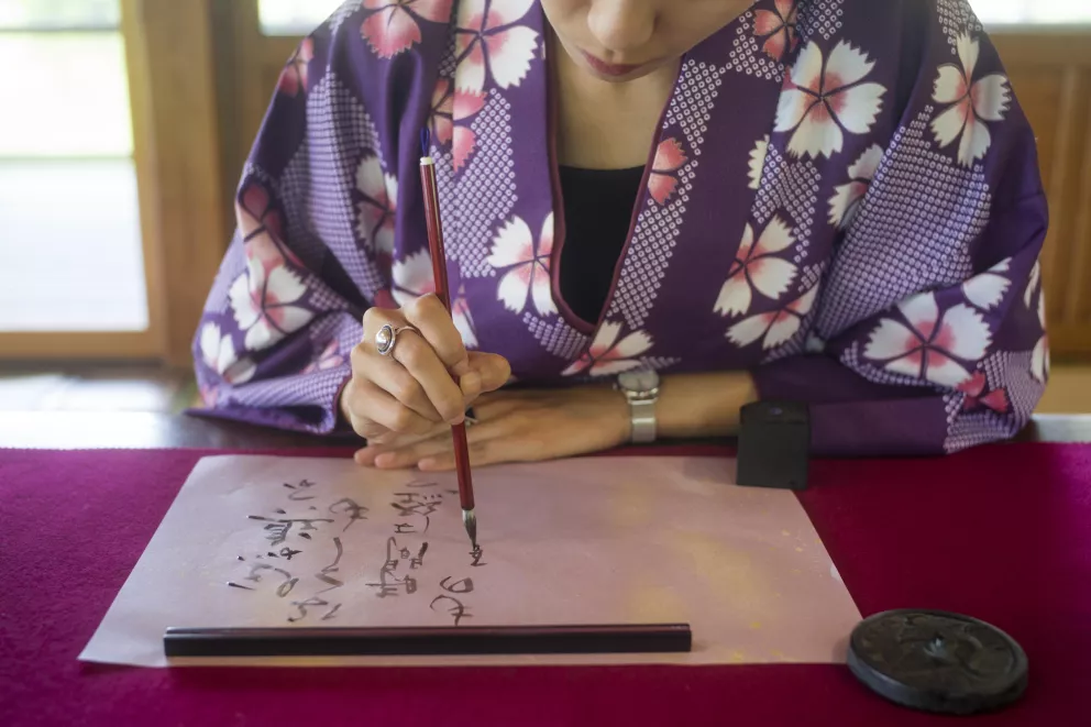 Japonka píše kaligrafii