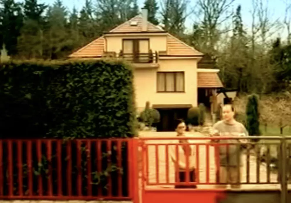 muž natírá plot pod dohledem tchyně