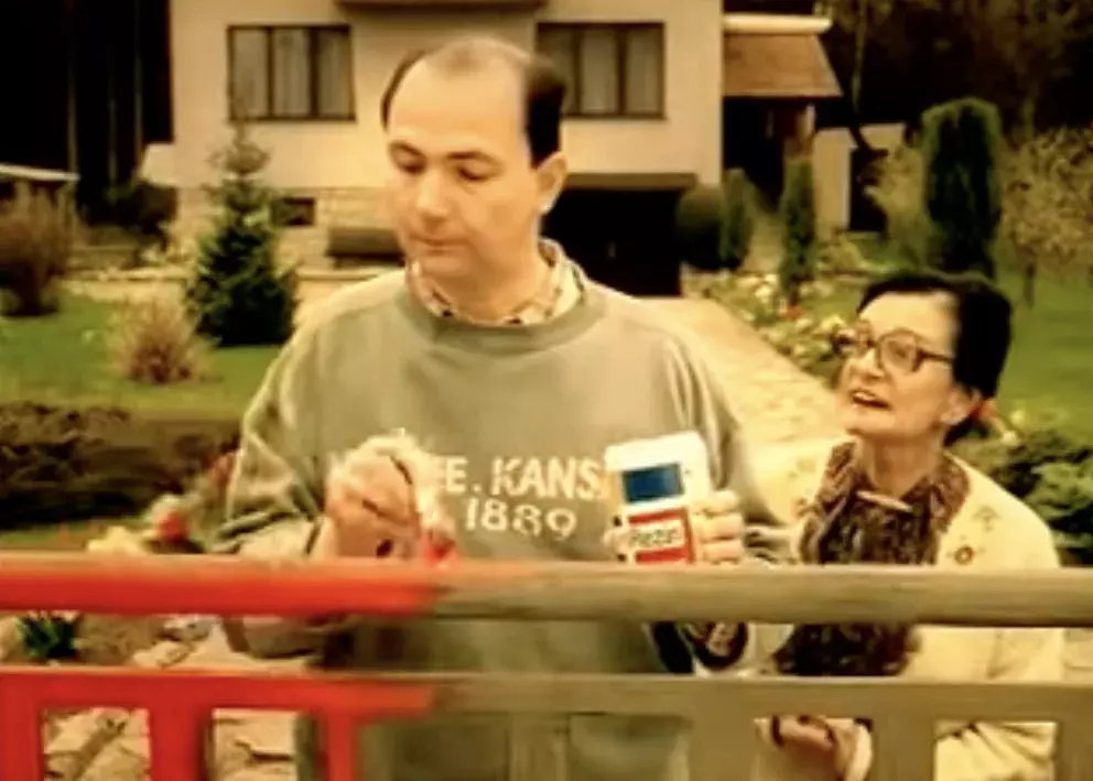 muž natírá plot pod dohledem tchyně