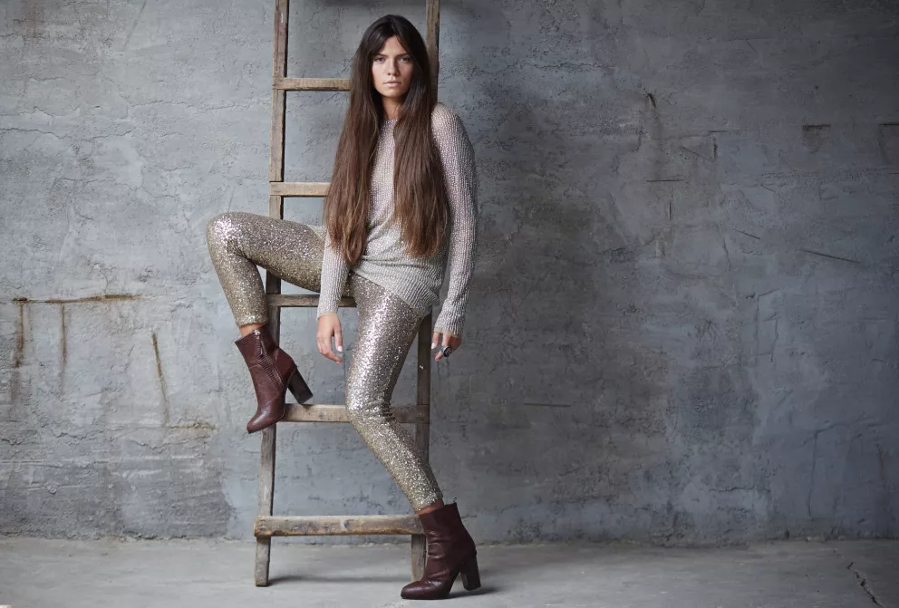 žena v moderních metalických kalhotách