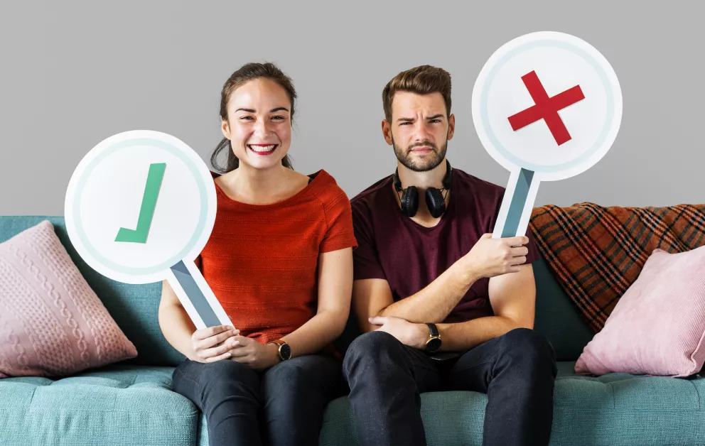 dva lidé na gauči s cedulemi ano, ne