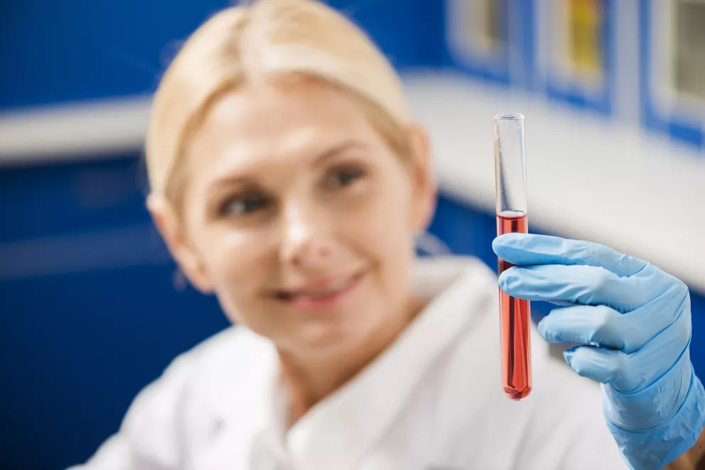 žena držící zkumavku se vzorkem krve