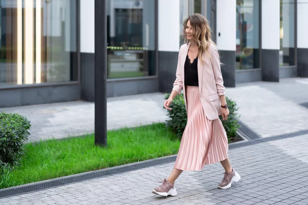 Žena v trendy teniskách a sukni