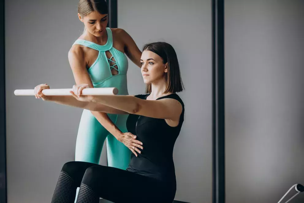 Žena cvičící s trenérkou