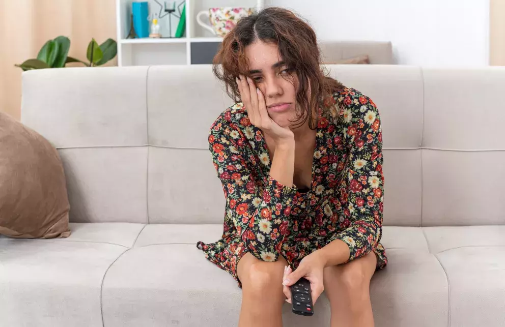 smutná žena, ovladač, pohovka