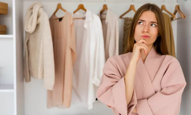Žena přemýšlející nad výběrem outfitu