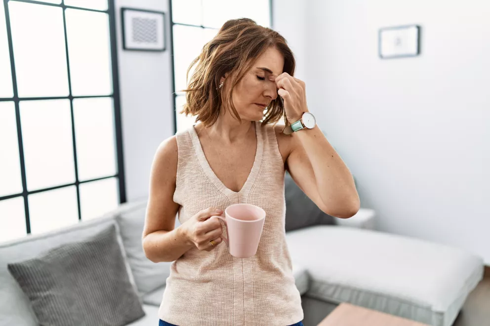 unavená žena s hnkem kávy v ruce