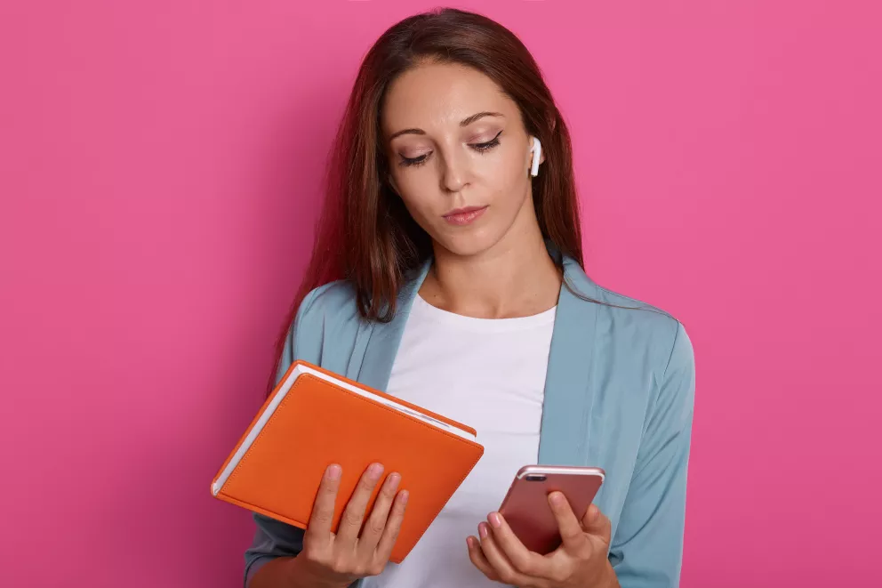 žena s mobilem a sešitem