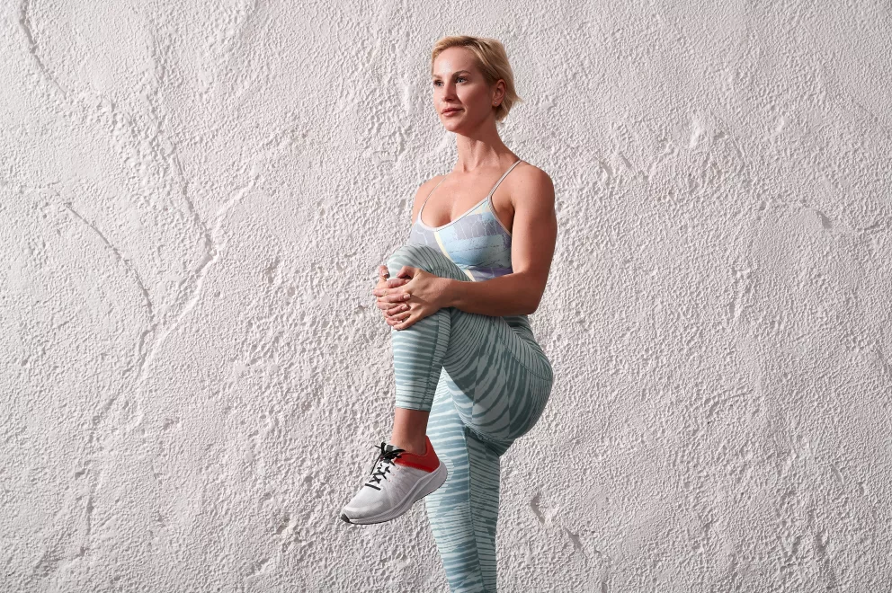 žena stojí na jedné noze