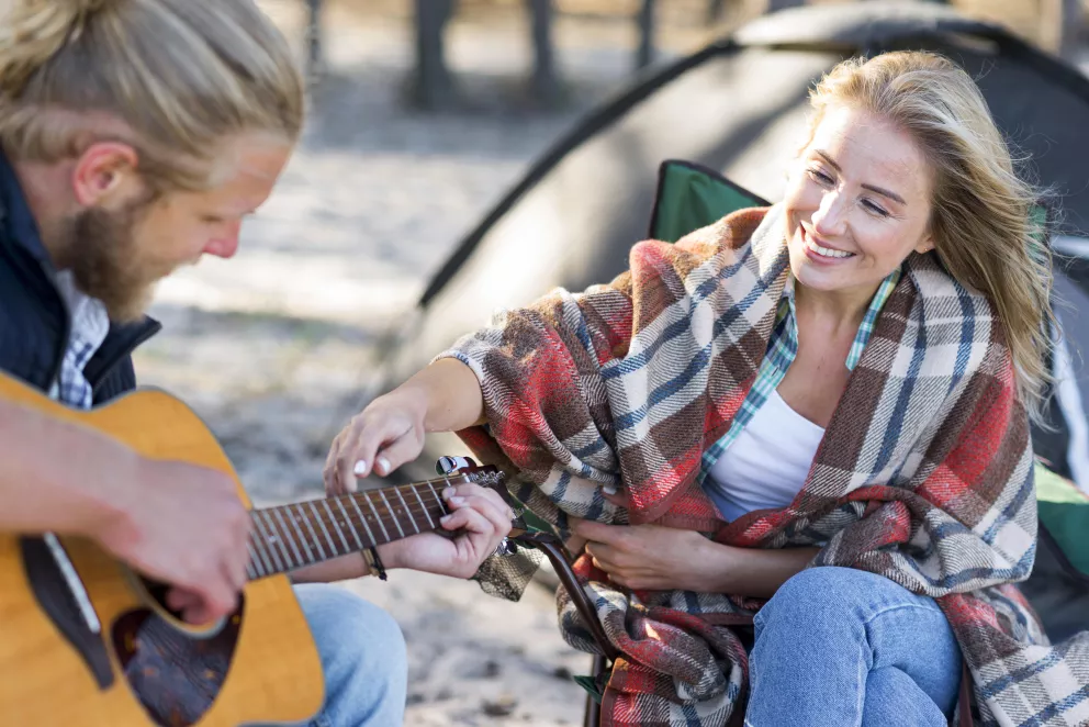 muž hraje na kytaru pod širákem