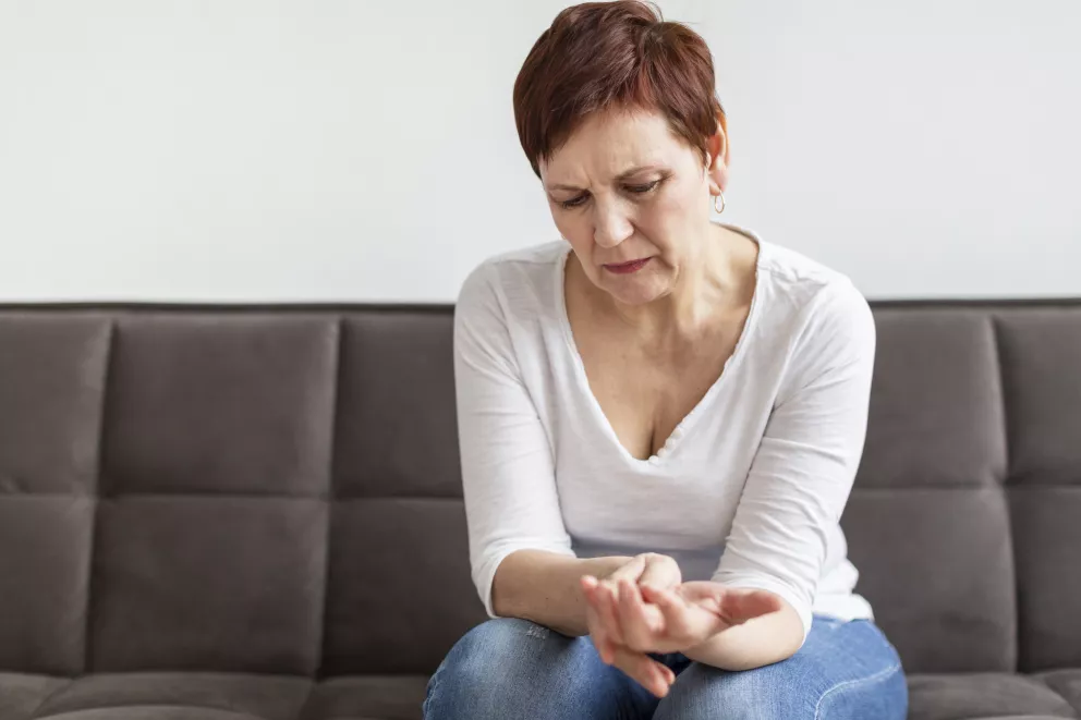 žena si drží bolavou ruku