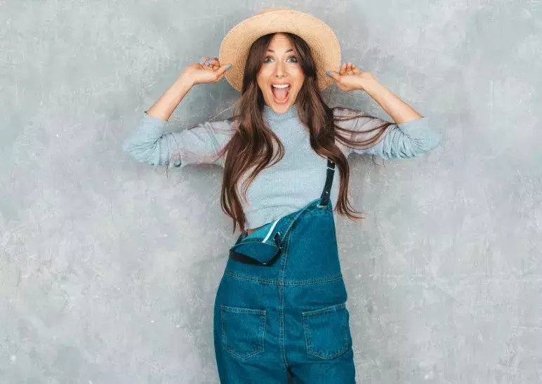 žena v lacláčích a klobouku