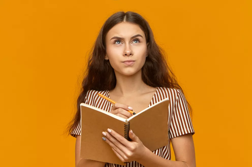 dívka s otevřeným sešitem píše