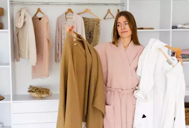 žena držící oblečení