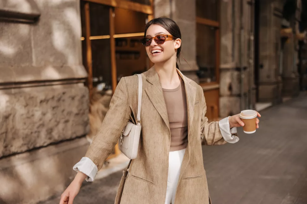 žena s kávou oblečená v odstínech hnědé a béžové