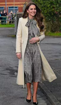 <p>Kostkované šaty patří mezi oblíbené kousky Kate Middleton a v kombinaci s béžovým kabátem působí nesmírně elegantně. Béžová barva krásně zjemňuje výraznější vzor a dodává outfitu nadčasový nádech. Celek působí vyváženě a dokonale ladí s podzimní paletou barev. Tento look je skvělou inspirací, jak kombinovat vzory s neutrálními tóny.</p>
