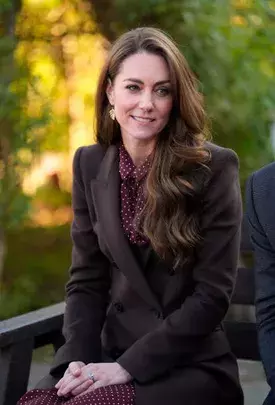 <p>Hnědý kabát v kombinaci s vínovou halenkou s puntíky působí na Kate Middleton hravě i elegantně zároveň. Tmavší odstín kabátu celý look zklidňuje, zatímco výrazná halenka dodává outfitu osobitý šmrnc. Puntíkový vzor odlehčuje formálnější charakter kabátu a přináší do podzimního stylu svěžest. Celek je důkazem, že i drobné detaily dokážou změnit náladu celého outfitu.</p>
