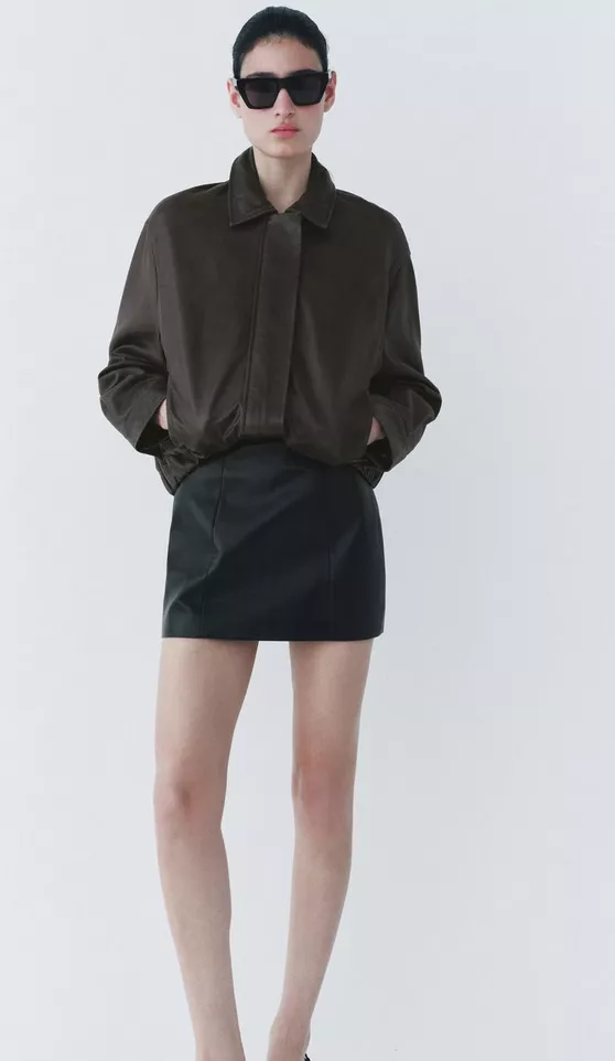 <p>Černá koženková minisukně, ZARA, 1 999 Kč</p>
