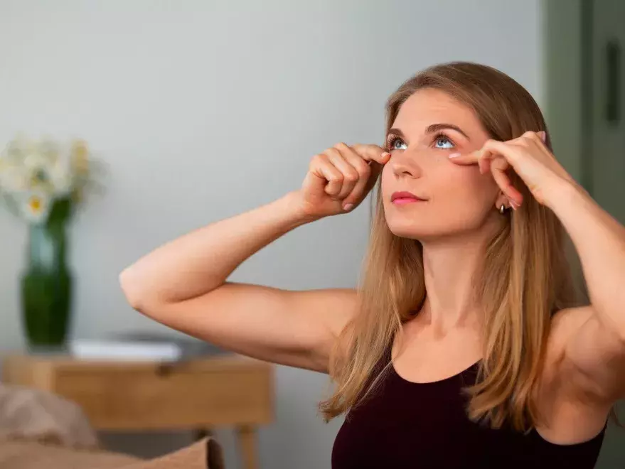 žena masíruje oční okolí