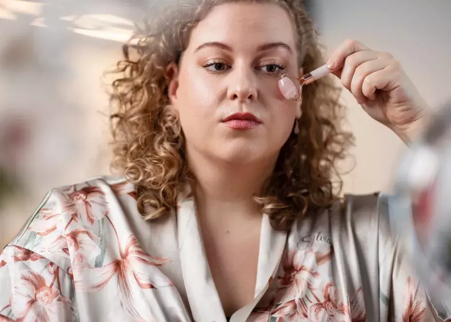 žena masíruje oční okolí kamenným válečkem