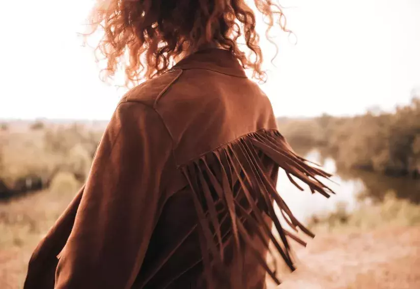 žena v bundě s třásněmi