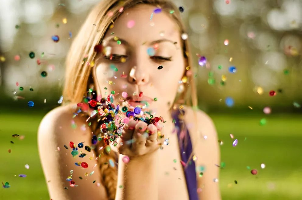 žena fouká do třpytek