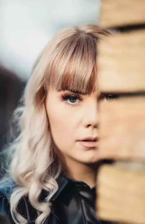 žena s rovnou ofinou a blond vlasy