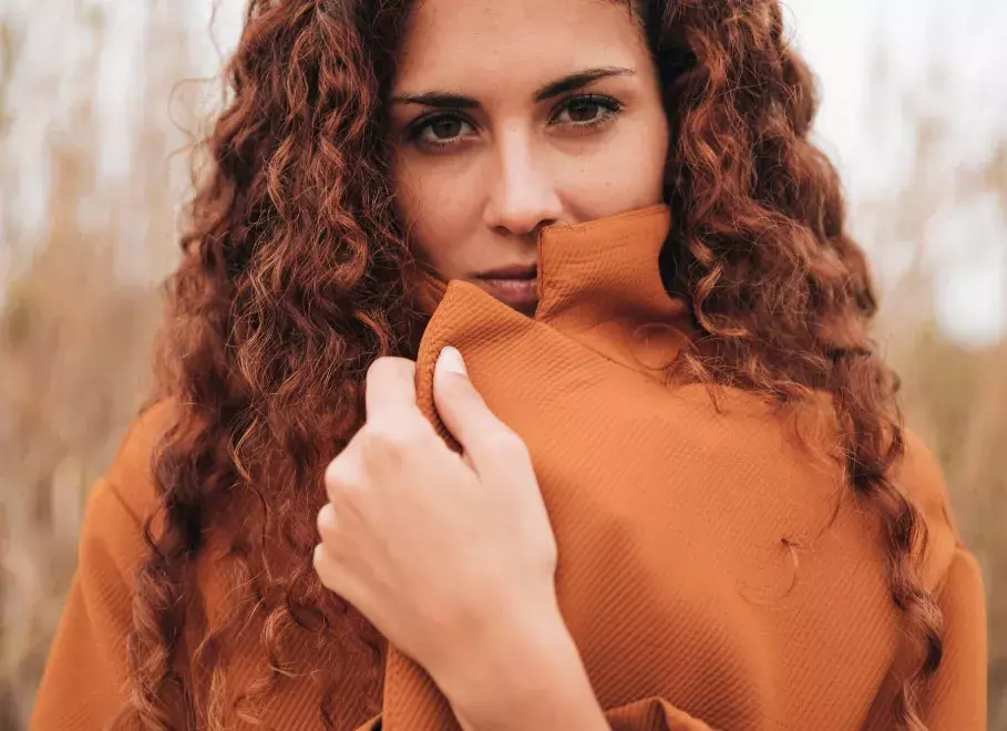 žena s hnědými vlnitými vlasy