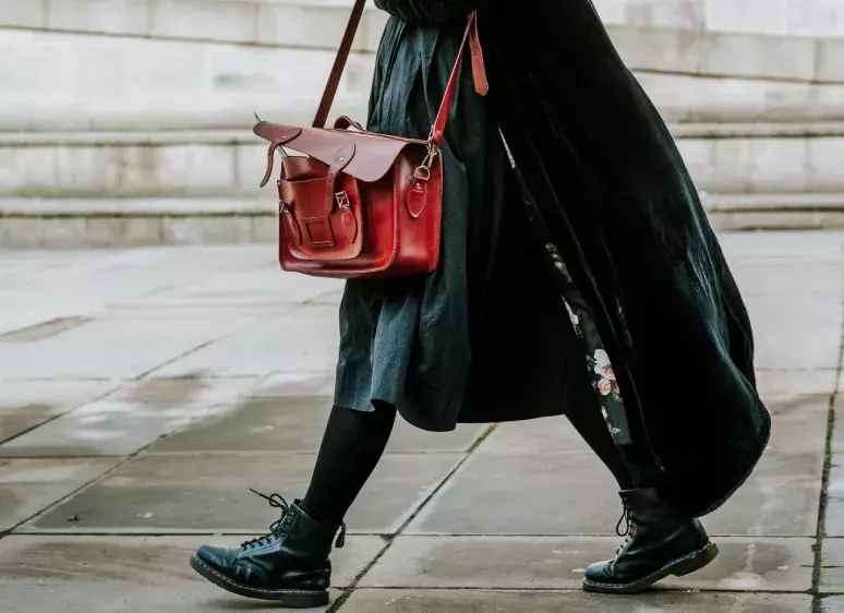 žena v černém s hnědou kabelkou