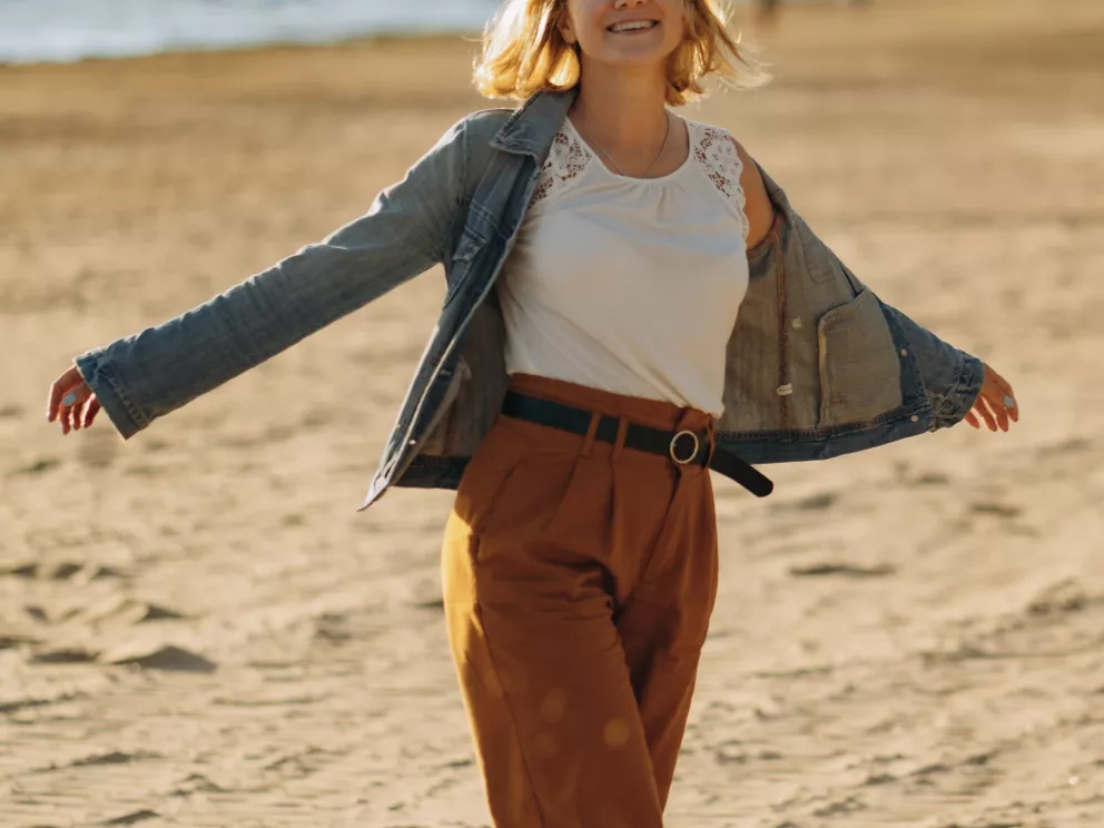 žena na pláži v kalhotách