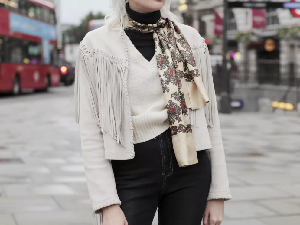 žena v krátkém kabátku s třásněmi