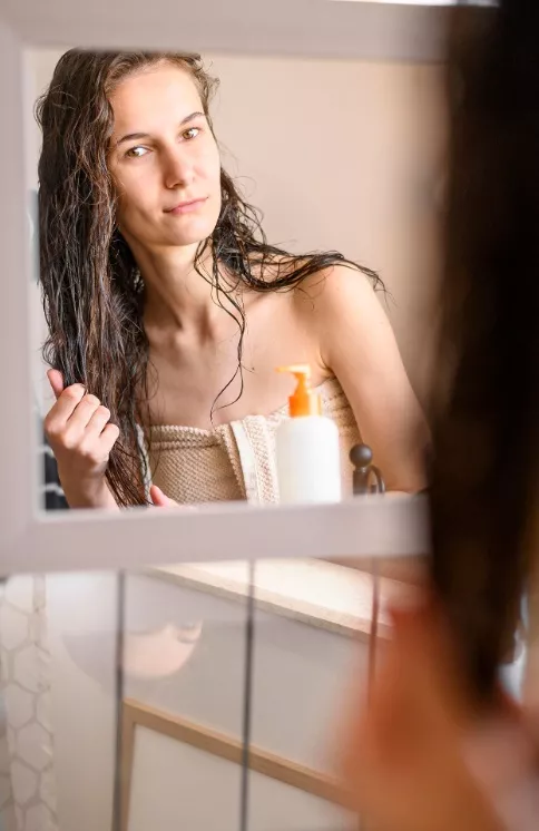 žena si dává masku na vlasy