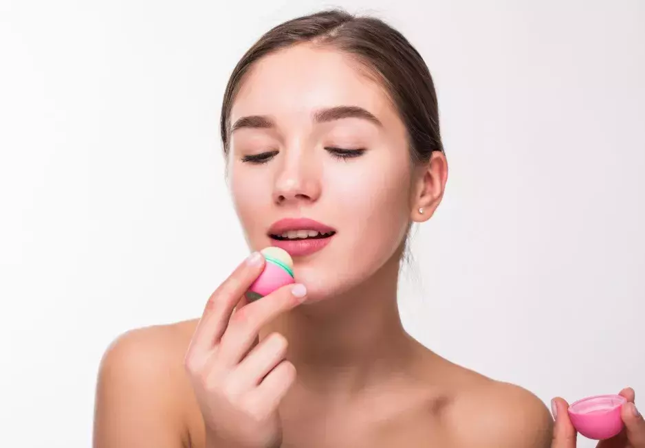 žena s balzámem na rty v kalíšku