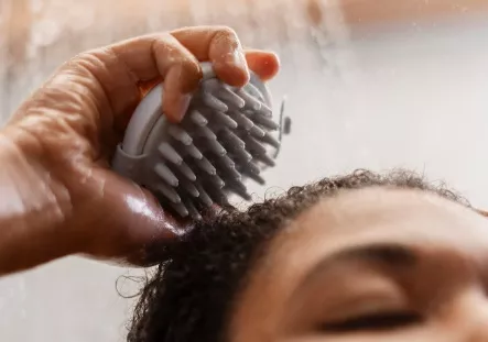 žena s masážním kartáčem an vlasy