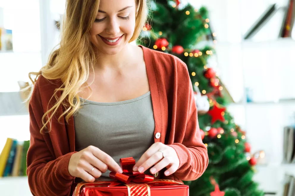 žena rozbaluje vánoční dárek