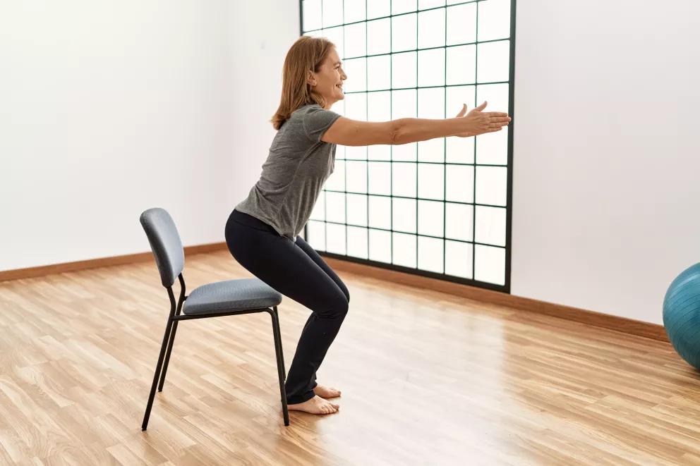 žena dřepuje na židli