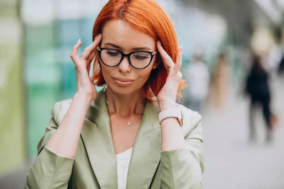 žena si drží hlavu