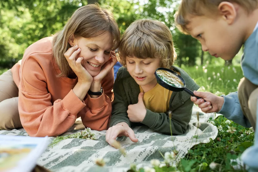 matka s dětmi pozorují hmyz lupou