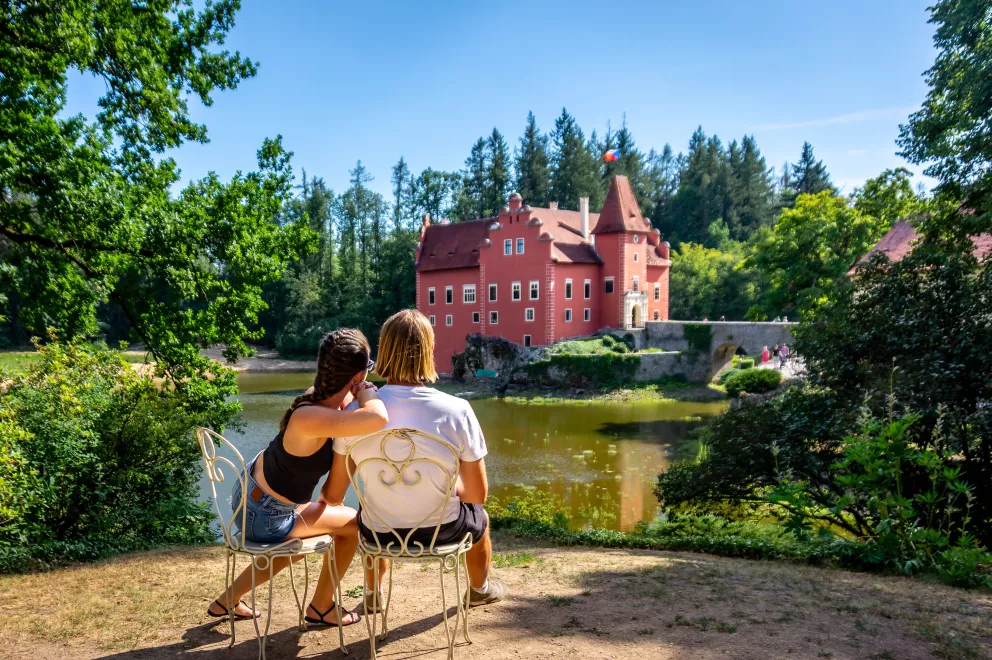 pár sedí na židli před Červenou Lhotou