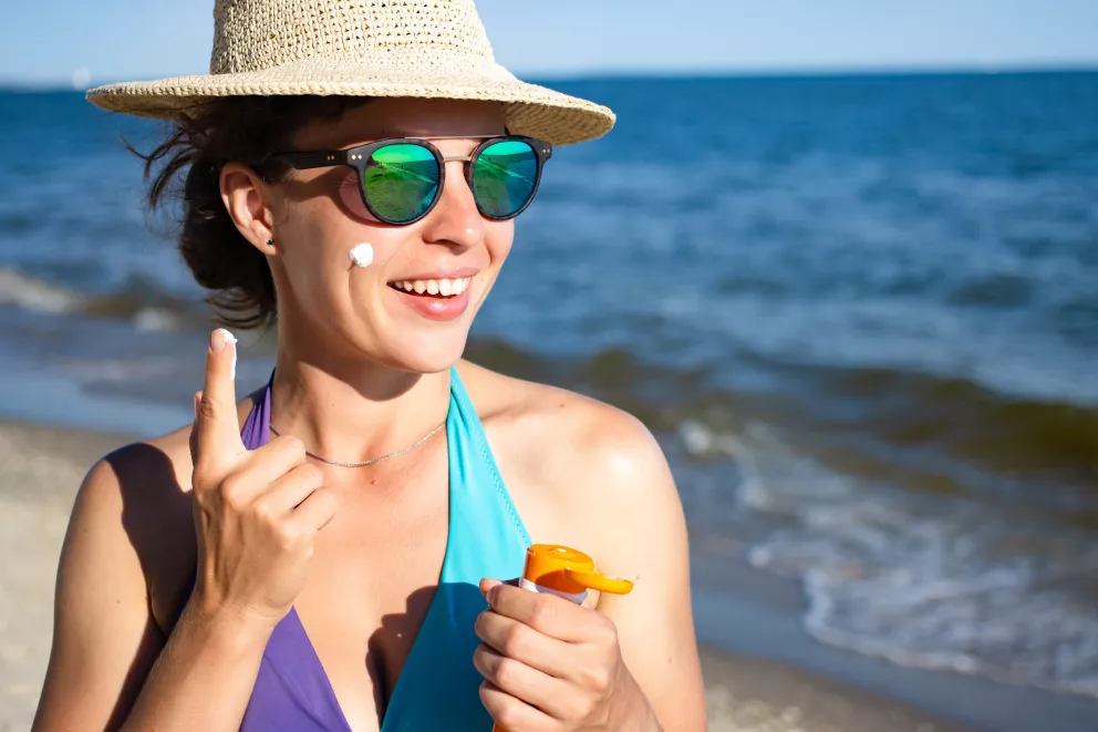 žena se maže opalovacím krémem