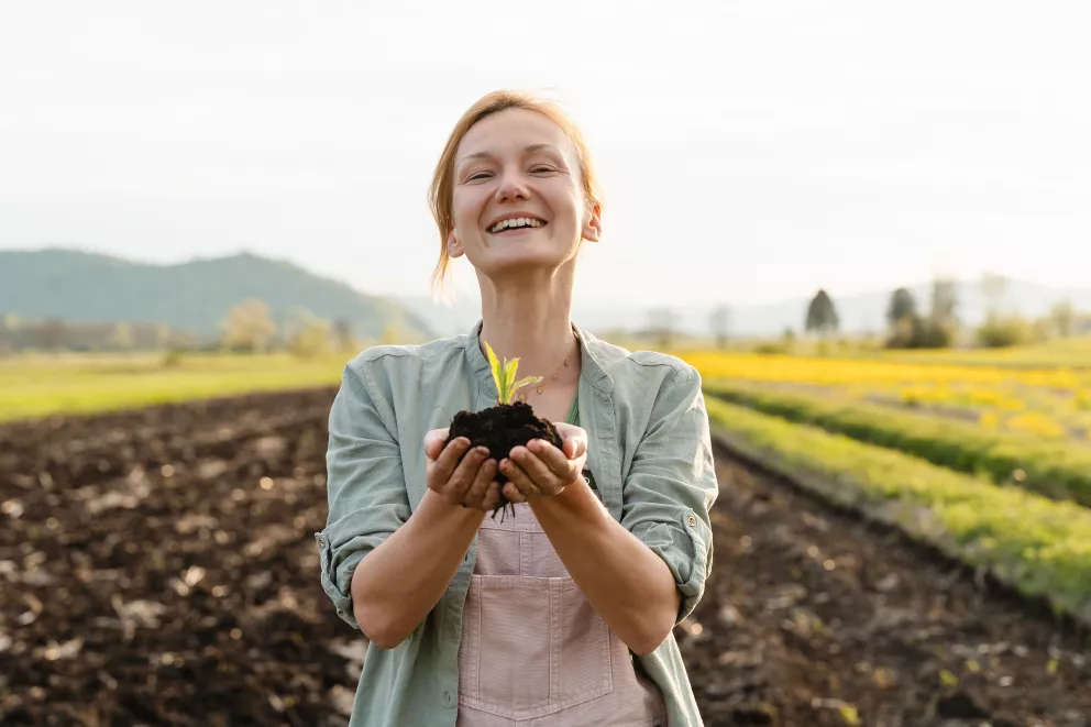 žena s mladou rostlinkou v ruce