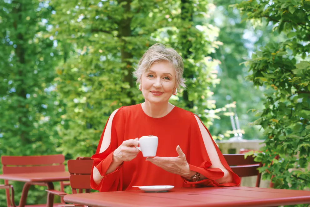 žena popíjí na zahrádce kávu