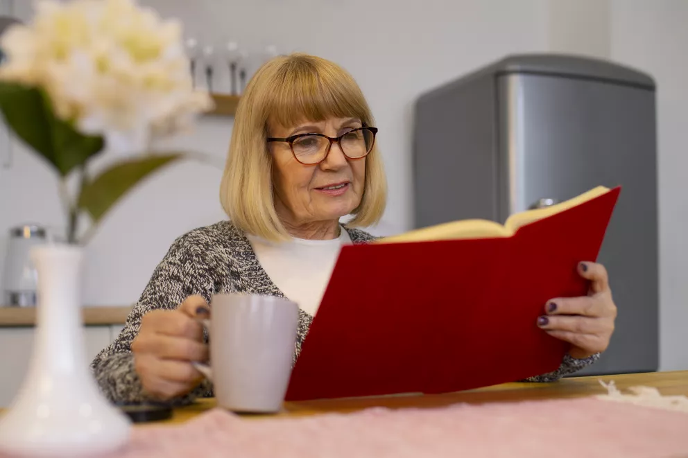 žena s knihou a hrnečkem v ruce