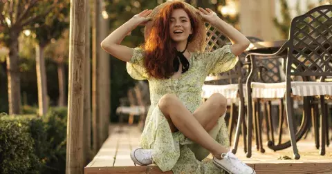 Midi šaty a plátěné tenisky jsou nadčasová letní kombinace, která sluší i ženám po 50